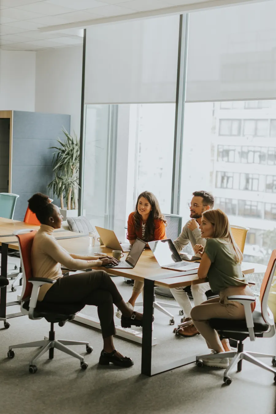 Equipe reunida em volta de uma mesa com notebooks